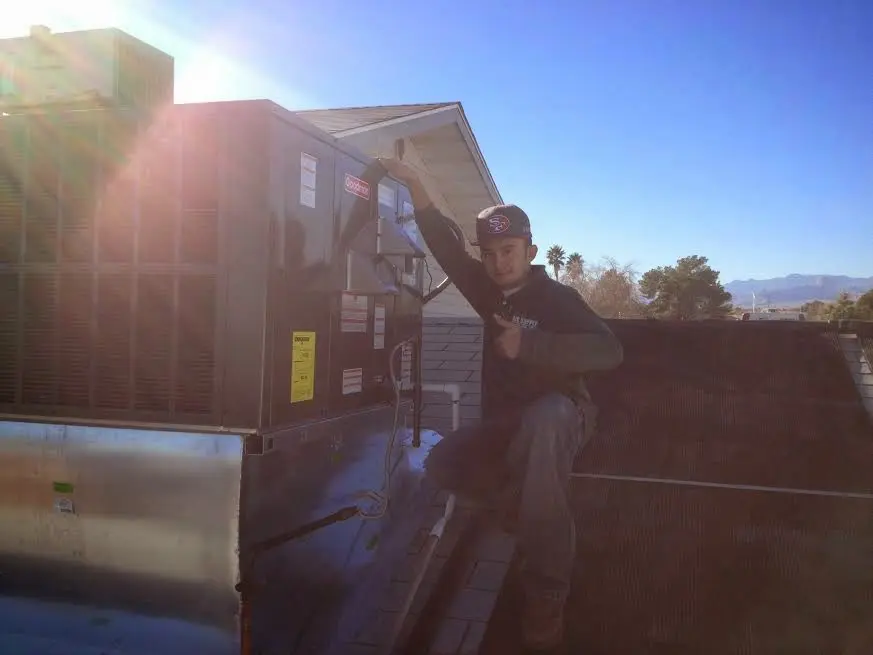 HVAC technician performing AC Tune-Up on a rooftop unit in Marshfield